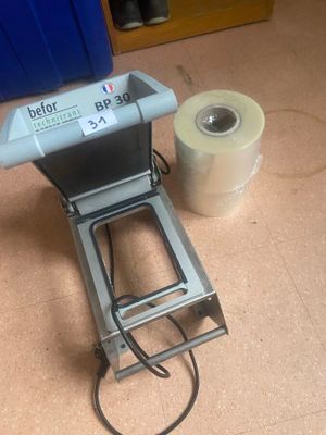 a machine that is sitting on the floor next to a roll of toilet paper