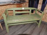 un banc vert dans une pièce au sol en parquet