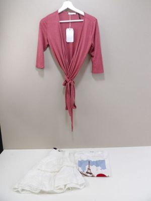 un lit blanc avec une chemise rose accrochée au mur