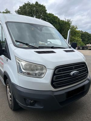 la camionnette blanche est garée sur un parking avec des arbres en arrière-plan