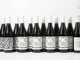 six bouteilles de vin sont alignées sur une table