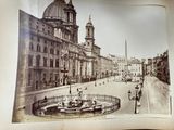 an old photo of a city street with a fountain in the middle