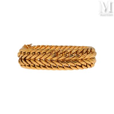gros plan d'un bracelet en or sur fond blanc
