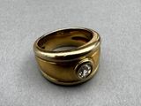 a gold ring with a diamond in it on a table