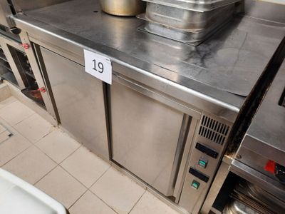un plan de travail en acier inoxydable sur lequel sont posés des casseroles et des poêles, dans une cuisine professionnelle