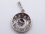 a close up of a silver pendant with a skull inside of it