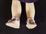 a close up of a doll ' s legs with shoes on