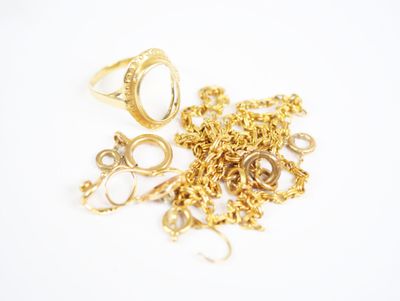 a pile of gold rings and chains on a white surface