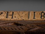 a close up of a wooden plaque with the name of a building