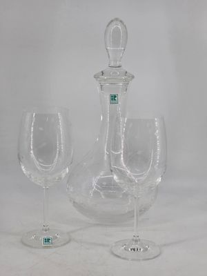 two wine glasses and a decanter sitting on a table