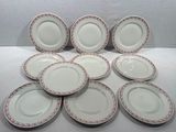 six assiettes blanches ornées de motifs rouges et blancs, posées sur une table