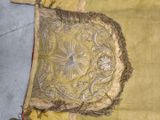 a yellow bag with a gold design on it