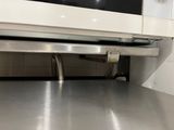 a microwave that is under the counter in the kitchen