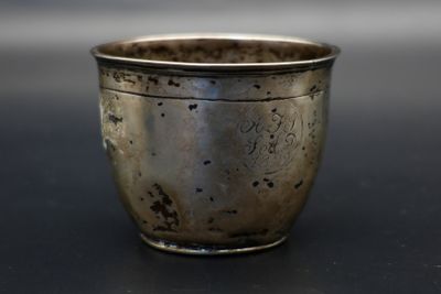 une coupe en argent posée sur une table, sur fond noir