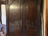 a large wooden armoire in the corner of a room