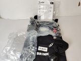 une chemise noire et une paire de gants posés sur une table blanche