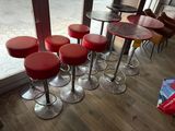 several red stools sit in front of a window in a restaurant