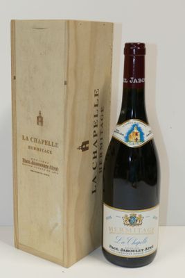une bouteille de vin rouge dans un coffret en bois, à côté d'un coffret en bois