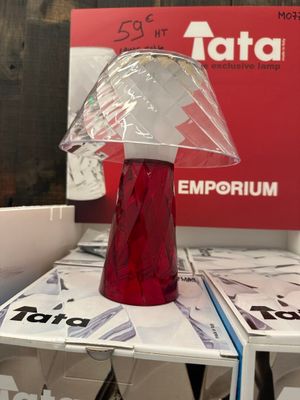 un vase rouge posé sur des cartons