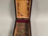 a small wooden box that is open on a white surface