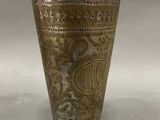 a silver cup with a design on it
