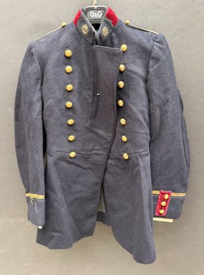 un vieux manteau militaire accroché au mur à côté d'un porte-manteau