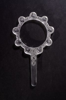 a close up of a small glass object on a black surface