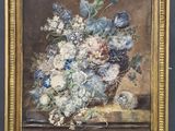 an oil painting of flowers in a vase on a wooden easel