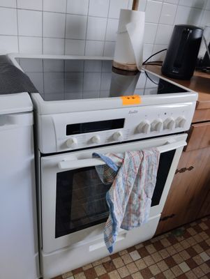 a white stove top oven sitting in a kitchen next to a dishwasher