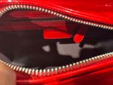 a person holding a red purse with an apple logo on it