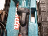 a corded drill sitting on top of a blue tool box