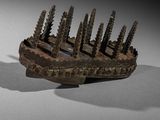 an old wooden comb with many screws on it