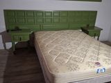 a bed that has a green headboard on it