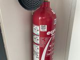 un extincteur rouge fixé au mur