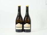 deux bouteilles de vin posées l'une à côté de l'autre sur une surface blanche