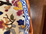 a decorative plate with flowers on it on a wooden table