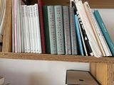 many books on a wooden shelf in a room