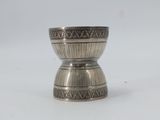 a silver cup sitting on top of a white table