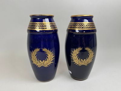 une paire de vases bleus ornés de motifs dorés sur fond blanc