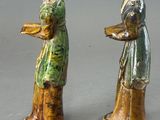 two figurines that are standing next to each other