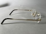 pair of clear glasses with gold rims on a white surface