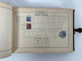 an open book with stamps on it on a table