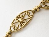 an image of a close up of a gold bracelet with a chain