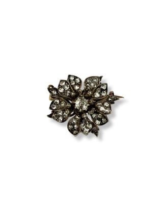 un gros plan d'une broche en forme de fleur sur fond blanc