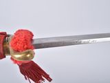 someone is holding a sword with a red tassel attached to it