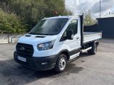 Le fourgon Ford Transit blanc est garé sur un parking.