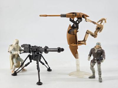 trois figurines qui se tiennent côte à côte