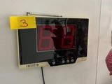 une horloge accrochée au mur à côté d'une peluche