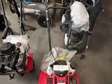 Plusieurs tondeuses à gazon sont rangées dans un garage