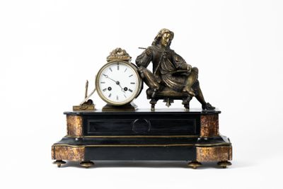 une statue représentant un homme assis sur une table, à côté d'une horloge